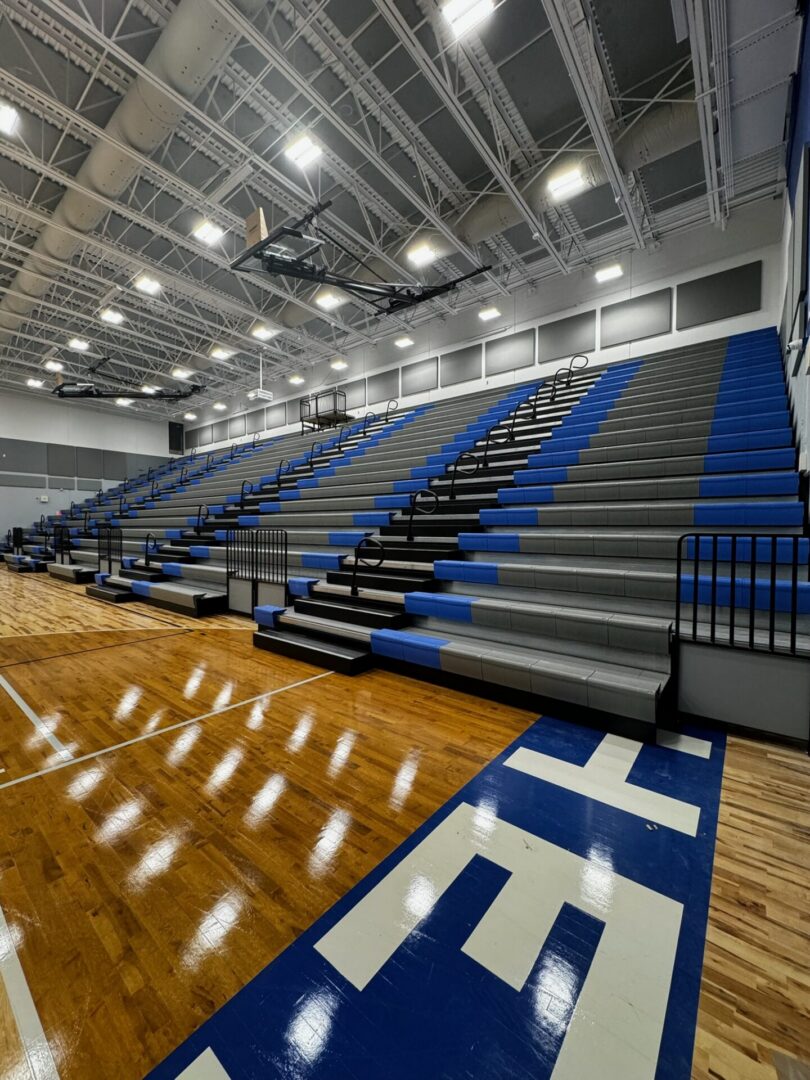 Empty gymnasium with blue-gray bleachers