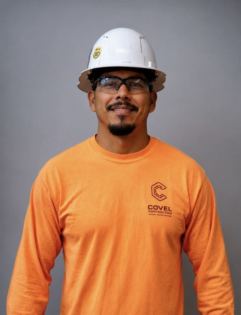 Smiling worker in orange shirt and helmet